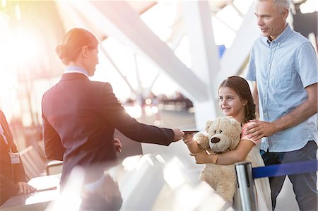 service people - Flight attendant checking ticket of girl with teddy bear in airport Stock Photo - Premium Royalty-Free, Code: 6113-08784192