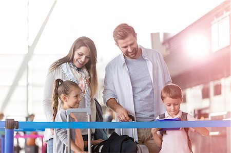 Family with suitcases in airport Stock Photo - Premium Royalty-Free, Code: 6113-08784127
