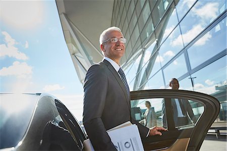 rich man and luxury - Smiling businessman arriving at airport getting out of town car Stock Photo - Premium Royalty-Free, Code: 6113-08784284