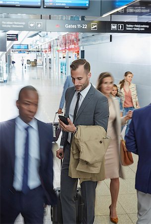 simsearch:700-03058969,k - Businessman using cell phone in airport concourse Stock Photo - Premium Royalty-Free, Code: 6113-08784321