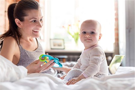 Portrait mother and daughter playing on bed Stock Photo - Premium Royalty-Free, Code: 6113-08784429