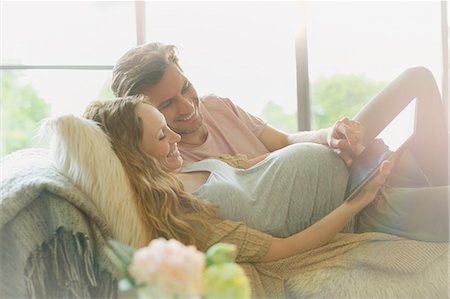 simsearch:614-06169336,k - Pregnant couple laying relaxing using digital tablet Foto de stock - Sin royalties Premium, Código: 6113-08721981