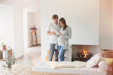 simsearch:6113-06753677,k - Pregnant couple using digital tablet near fireplace Stock Photo - Premium Royalty-Free, Code: 6113-08721984