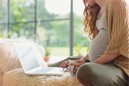 simsearch:6113-06753677,k - Pregnant woman drinking tea and using laptop Stock Photo - Premium Royalty-Free, Code: 6113-08721994