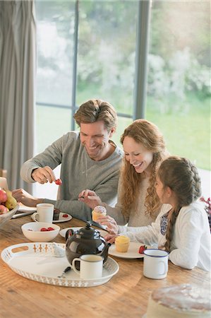 simsearch:6113-06720252,k - Family eating cupcakes and fruit at dining table Stock Photo - Premium Royalty-Free, Code: 6113-08722086