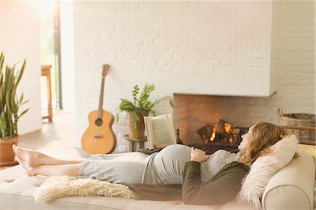 Serene pregnant woman laying on chaise next to fireplace in living room Stock Photo - Premium Royalty-Free, Code: 6113-08722014