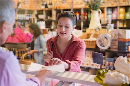 southeast asian - Woman sampling cheese at deli counter in market Stock Photo - Premium Royalty-Free, Code: 6113-08722174