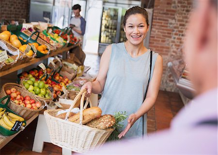 simsearch:649-07119168,k - Woman with basket smiling at grocery store worker Stock Photo - Premium Royalty-Free, Code: 6113-08722136