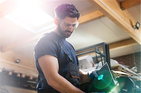 simsearch:6113-08220197,k - Steel worker using sander in workshop Foto de stock - Sin royalties Premium, Código: 6113-08722241