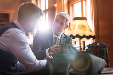 Tailor and businessman discussing suit in menswear shop Stock Photo - Premium Royalty-Free, Code: 6113-08722354
