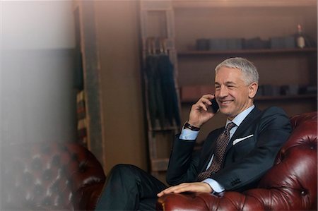 simsearch:649-07520071,k - Smiling businessman talking on cell phone in menswear shop Stock Photo - Premium Royalty-Free, Code: 6113-08722301