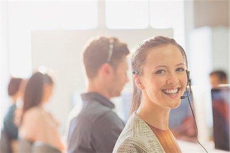 Portrait smiling female telemarketer wearing headset in office Stock Photo - Premium Royalty-Free, Code: 6113-08882449