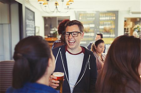 simsearch:6113-07147381,k - Man laughing and drinking beer with friends at bar Stock Photo - Premium Royalty-Free, Code: 6113-08882551
