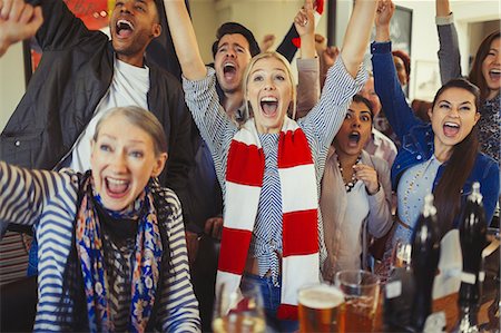 Enthusiastic sports fans cheering watching game in bar Foto de stock - Sin royalties Premium, Código: 6113-08882556