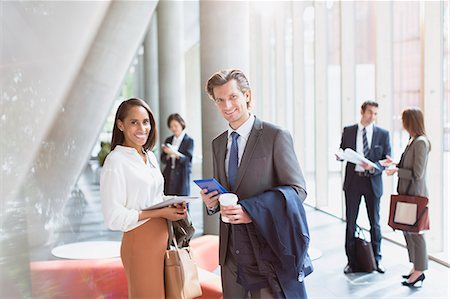 simsearch:6113-07243187,k - Portrait smiling businessman and businesswoman in sunny office lobby Stock Photo - Premium Royalty-Free, Code: 6113-08882503