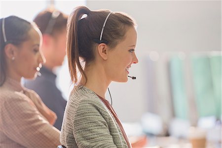 simsearch:6113-07243082,k - Smiling female telemarketer wearing headset talking on telephone in office Stock Photo - Premium Royalty-Free, Code: 6113-08882512