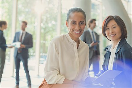 simsearch:6113-07243187,k - Portrait smiling businesswomen with digital tablet in office lobby Stock Photo - Premium Royalty-Free, Code: 6113-08882531