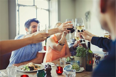 simsearch:6113-06909171,k - Friends celebrating, toasting wine glasses and dining at restaurant table Stock Photo - Premium Royalty-Free, Code: 6113-08882654