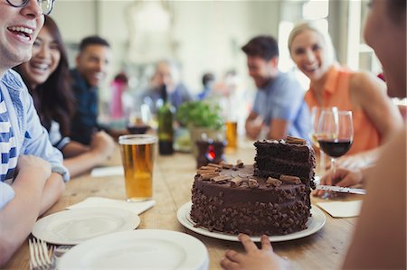 Woman serving chocolate birthday cake to friends at restaurant table Stock Photo - Premium Royalty-Free, Code: 6113-08882690