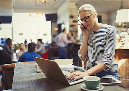 Creative businesswoman talking on cell phone and using laptop in cafe Foto de stock - Sin royalties Premium, Código: 6113-08882610