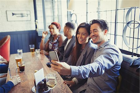 simsearch:6113-07790692,k - Smiling couple taking selfie with camera phone at table in bar Stock Photo - Premium Royalty-Free, Code: 6113-08882636