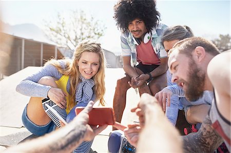 simsearch:6113-08743448,k - Personal perspective man showing friends video on smart phone at sunny skate park Stock Photo - Premium Royalty-Free, Code: 6113-08882744