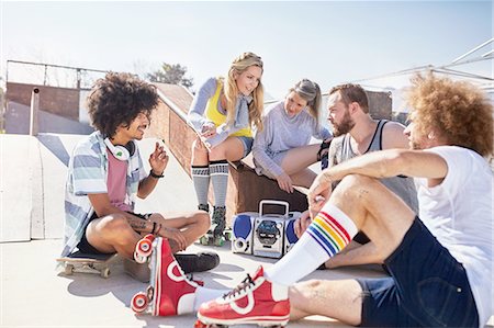 Friends in roller skates hanging out listening to music at sunny skate park Stock Photo - Premium Royalty-Free, Code: 6113-08882709