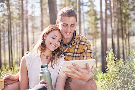 front of hiker - Young couple camping, drinking coffee and using digital tablet in sunny woods Stock Photo - Premium Royalty-Free, Code: 6113-08882846