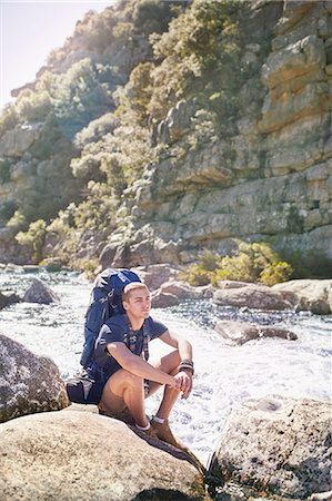 simsearch:632-05604251,k - Young man with backpack hiking, resting on rocks at sunny river Photographie de stock - Premium Libres de Droits, Code: 6113-08882865