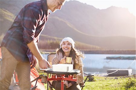 simsearch:6113-07147024,k - Young couple camping, cooking at camping stove at sunny lakeside Stock Photo - Premium Royalty-Free, Code: 6113-08882805