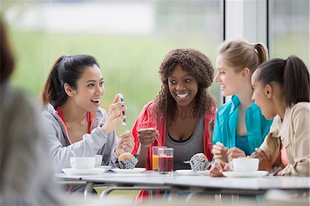simsearch:6113-08743448,k - Smiling women drinking coffee and juice using cell phone in cafe post workout Stock Photo - Premium Royalty-Free, Code: 6113-08805384