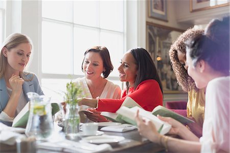 Women friends discussing book club book at restaurant table Stock Photo - Premium Royalty-Free, Code: 6113-08805311