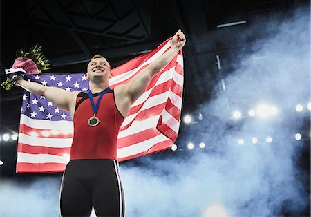 simsearch:6113-07648679,k - Male gymnast celebrating victory holding American flag on winners podium Stock Photo - Premium Royalty-Free, Code: 6113-08805441