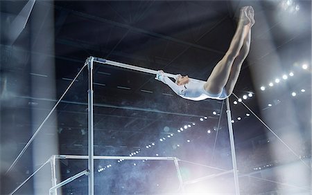 fit (tight clothes) - Female gymnast performing on uneven bars in arena Stock Photo - Premium Royalty-Free, Code: 6113-08805477