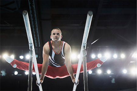Male gymnast performing splits on parallel bars Stock Photo - Premium Royalty-Free, Code: 6113-08805435