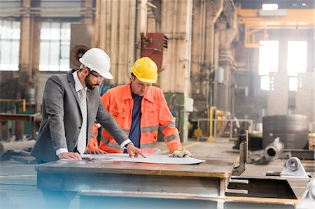 Manager and steel worker engineer reviewing blueprints in factory Fotografie stock - Premium Royalty-Free, Codice: 6113-08805565