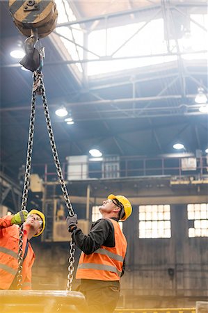 simsearch:6113-08805556,k - Steel workers looking up at crane chain in factory Stock Photo - Premium Royalty-Free, Code: 6113-08805569