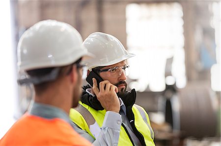 simsearch:6113-08805556,k - Steel workers talking on cell phone in factory Stock Photo - Premium Royalty-Free, Code: 6113-08805593