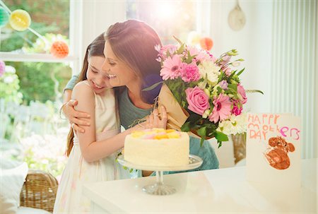 Affectionate daughter giving flower bouquet to mother on Mother's Day Stock Photo - Premium Royalty-Free, Code: 6113-08805679