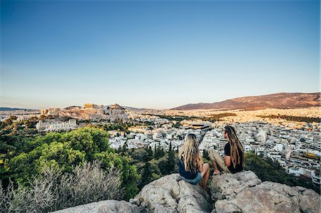 Couple sitting on rocks overlooking landscape, Athens, Greece Stock Photo - Premium Royalty-Free, Code: 6113-08805833