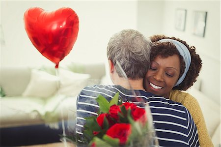 simsearch:649-06716867,k - Wife hugging husband giving Valentine's Day balloon and rose bouquet Stock Photo - Premium Royalty-Free, Code: 6113-08943581