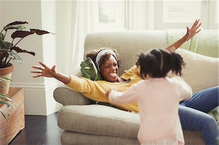 simsearch:6113-07543218,k - Enthusiastic mother on sofa greeting running daughter Stock Photo - Premium Royalty-Free, Code: 6113-08943584