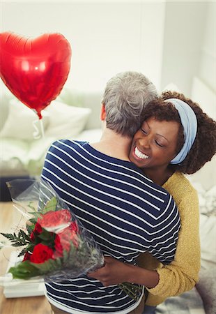 simsearch:649-06717611,k - Wife receiving Valentine's Day rose bouquet and balloon, hugging husband Foto de stock - Sin royalties Premium, Código: 6113-08943642