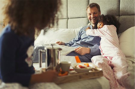 simsearch:700-00635521,k - Multi-ethnic daughter hugging father reading newspaper on bed Stock Photo - Premium Royalty-Free, Code: 6113-08943680