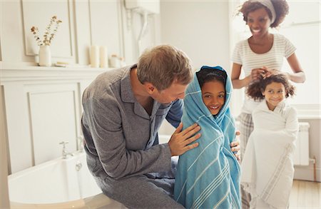 siblings bathing - Multi-ethnic parents drying daughters with towels after bath time in bathroom Stock Photo - Premium Royalty-Free, Code: 6113-08943602