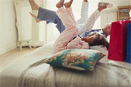 funny people happy caucasian - Father and daughters in pajamas kicking legs on bed Stock Photo - Premium Royalty-Free, Code: 6113-08943614