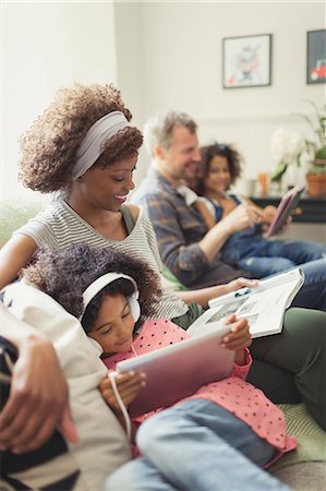 simsearch:6113-07730567,k - Multi-ethnic young family relaxing, reading and using digital tablet on sofa Stock Photo - Premium Royalty-Free, Code: 6113-08943639