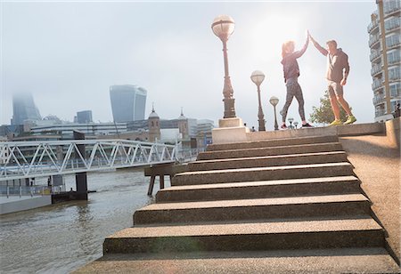 simsearch:6113-07648679,k - Runners high-fiving on sunny urban steps Stock Photo - Premium Royalty-Free, Code: 6113-08943771