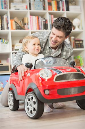 family inside car - Father pushing baby son in toy car Stock Photo - Premium Royalty-Free, Code: 6113-08947235