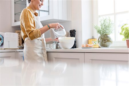 Woman baking, using electric hand mixer in kitchen Stock Photo - Premium Royalty-Free, Code: 6113-08947377